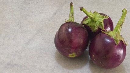 Fresh Purple Eggplants on Light Background