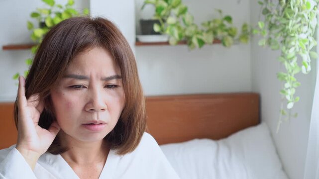 Asian woman experiencing schizophrenia symptoms, hearing voices and talking alone due to auditory hallucinations. psychotic disorder, inner voices, and mental-health