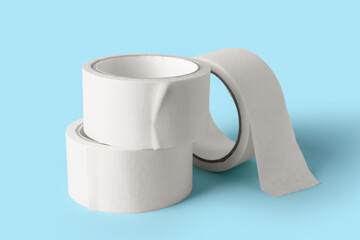 Rolls of white masking tape on blue background