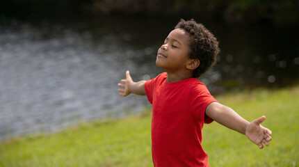 Child meditating in park by water