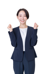 白い背景の前で、スーツ姿の女性が拳を握り、満面の笑顔でガッツポーズをしている