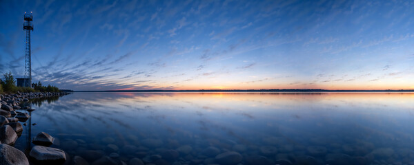 Communication tower landscape at sunset with lake reflection. Wireless 5G and 6G network technology infrastructure. Mobile internet data connection concept