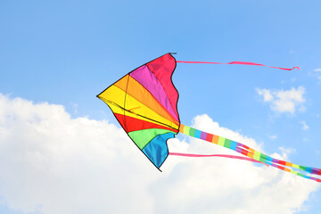Colorful kite flying in blue sky on sunny day