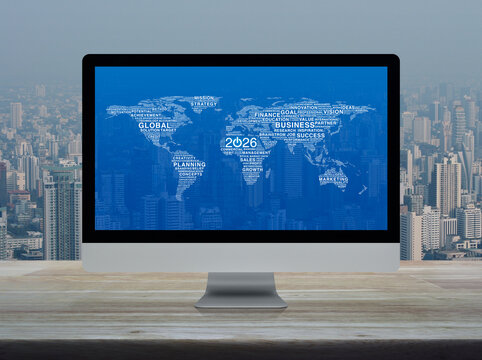 2026 start up business icon with global words world map on computer monitor screen on wooden table over office city tower and skyscraper, Happy new year 2026 start up online concept, Elements of this 