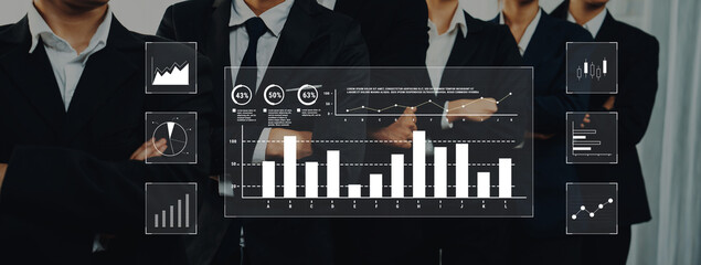 A professional business team examines financial data displayed on modern graphics, highlighting strategic planning and collaboration in a corporate environment. Trope