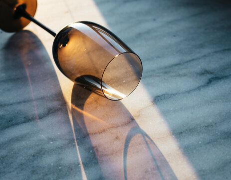 Elegant Champagne Glass on Marble Table, Sunlit Reflections, Abstract Fine Art Photography, Cocktail Hour, Beverage Aesthetics - Powered by Adobe