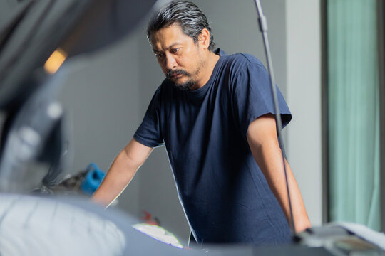 Car owner checking standing and looking at car engine. Car service, repair