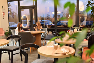 Friendship moment as two women hug and enjoy beverages together in a cafe