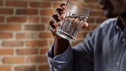 Man drinking water from a glass refreshing and hydrating. - Powered by Adobe