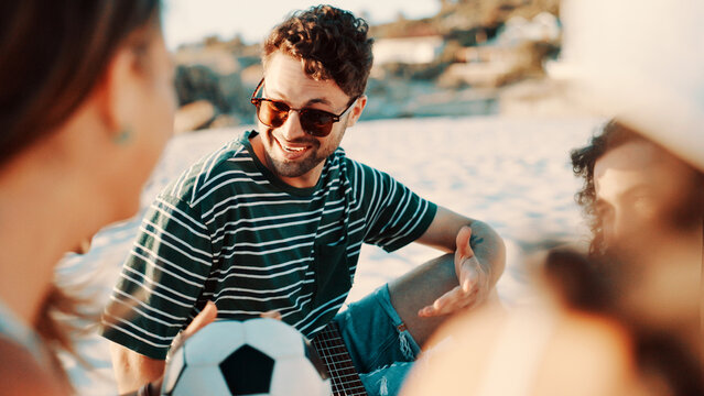 Outdoor, vacation and man with friends, talking and bonding on break, laugh or discussion with group. Happy, people and conversation on summer holiday, getaway and together in nature, trip and beach