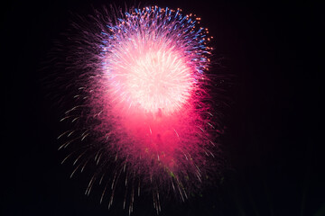 Brilliant white and gold fireworks exploding in starburst patterns against a pitch-black night sky during a celebration in Hue