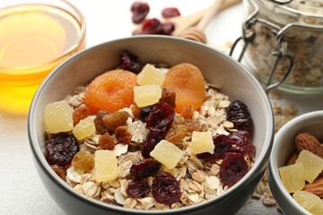 Making granola. Oat flakes, dried fruits and other ingredients on white table, closeup