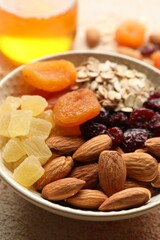 Making granola. Oat flakes, dried fruits and other ingredients on light table, closeup