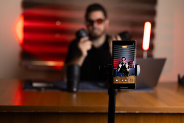 The man is setting up his equipment for a podcast recording session