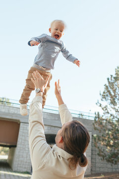 Father throwing happy toddler son in air