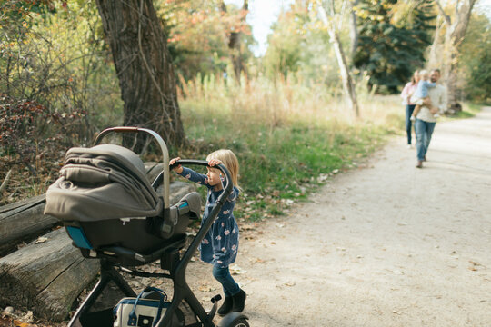 Family walking with children and stroller in park