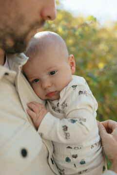 Father holding newborn baby boy outdoors creating bond