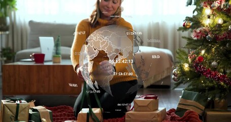 Woman kneeling tying ribbon globe appearing starting numeric overlay as placing gifts for marketing - Powered by Adobe