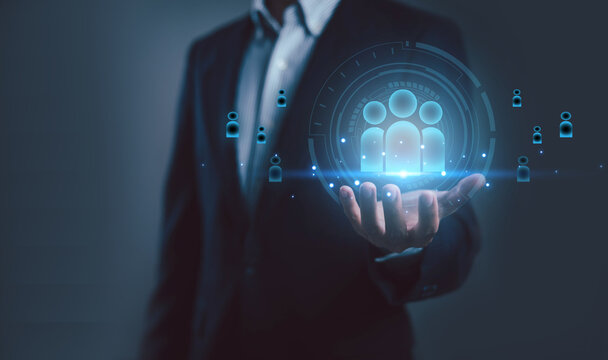 A business professional holding a glowing digital people icon represents customer management, human resources, teamwork, and data-driven connection, ideal for CRM, leadership, and organizational.