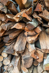 Close-up of a pile of broken firewood pieces with natural textures and organic shapes. A rustic material backdrop for construction, forestry, graphic purposes or nature themes.