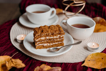 A slice of honey cake on a small plate in warm cozy light, showing layered texture and sweet rustic charm.