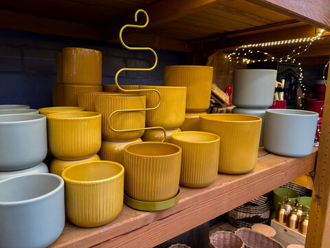 Different empty ceramic flower pots on wooden shelf at a gardening shop - Powered by Adobe