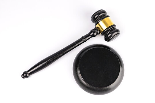 Close-up shot of a wooden gavel with golden handle and head, sound block, courtroom setting. m