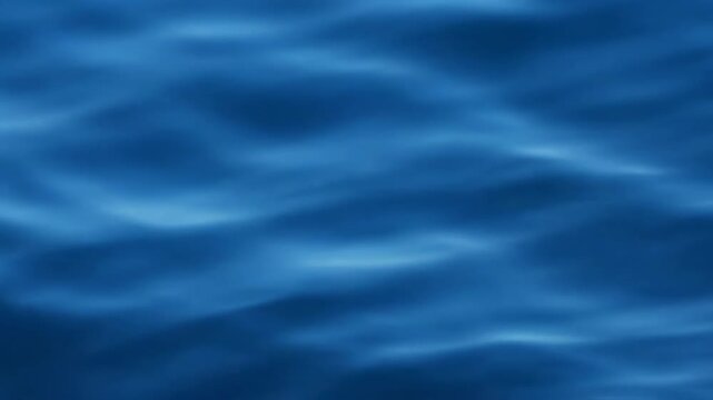 Top-down aerial view of subtle water surface ripples creating an undefined flowing texture against a blurred deep blue background perfect for abstract environmental themes purity, water, smooth