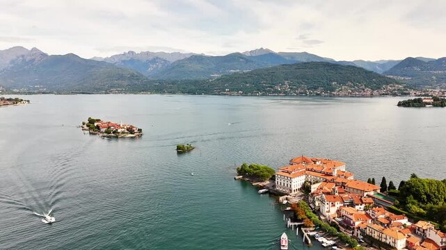 Aerial view of Isola Bellas Baroque palace and Isola dei Pescatoris red roofed village set in Lake Maggiore with Alpine peaks on the horizon, near Stresa, Verbano-Cusio-Ossola (VB), Piedmont, Italy