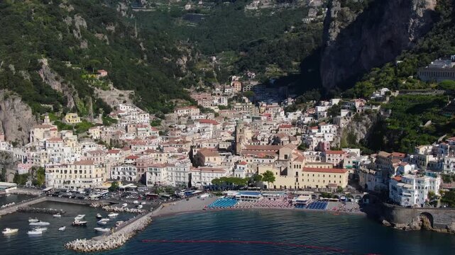 Zoom Out Aerial on Amalfi's Colorful Cliffside Homes Cascade Toward Sparkling Mediterranean, Creating a Breathtaking Scene Captured at Italian Coast. Drone Shot