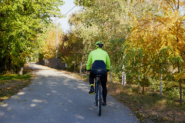 Obraz premium Old man exercising by riding a bicycle on a beautiful autumn day