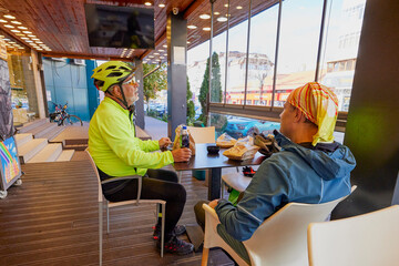 An old man who is passionate about cycling rides his bike with his son, enjoying a beautiful autumn day.