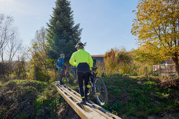An old man who is passionate about cycling rides his bike with his son, enjoying a beautiful autumn...