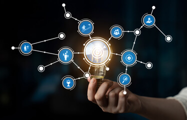 A hand holding a glowing light bulb symbolizes creativity and innovation. Surrounding icons...