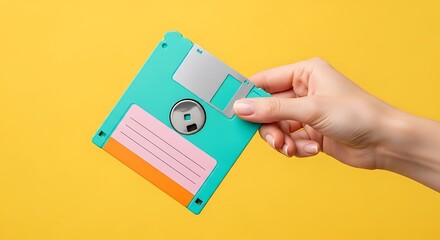 Hand holding a vintage teal floppy disk with yellow background diskette retro