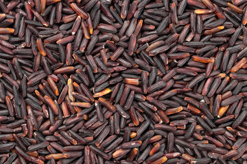 Top view of purple riceberry rice grains for background. Thai food