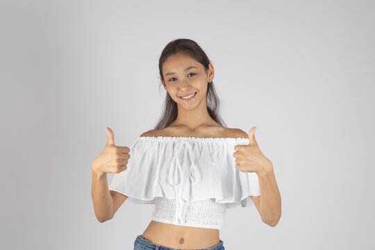 A woman is smiling and giving two thumbs up - Powered by Adobe