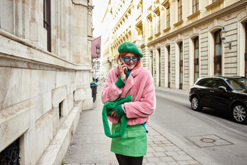 Young fashionable woman enjoys a leisurely stroll on a charming city street in vibrant attire