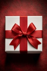 White gift box with red ribbon and bow on red background