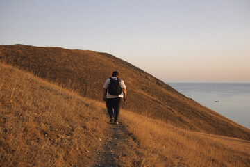 An overweight woman walks in the mountains, actively spends her weekend, active life, active lifestyle, excess weight.