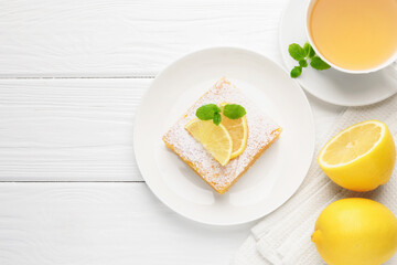 Tasty lemon bar with powdered sugar and mint served on white wooden table, flat lay. Space for text