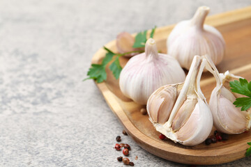 Garlic, peppercorns and parsley on light table, closeup. Space for text