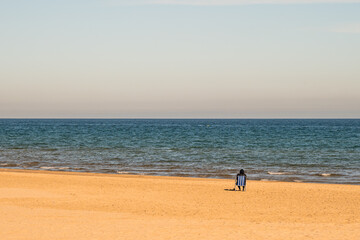 Person on his back sitting on a chair on the beach contemplating the sea. Empty space