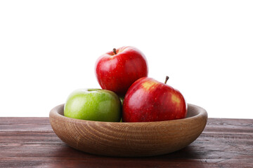 Red and green ripe apples in bowl on wooden table against white background