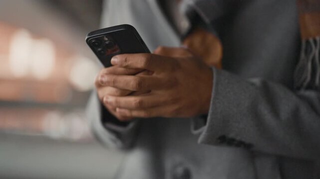 Modern model of smartphone in hands of black man, internet addiction, gadget use . Anonymous internet user messaging in social networks, cybersecurity and cyber criminals, safety in internet site