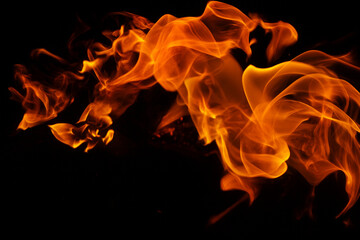 Abstract orange flames swirling on black background, dramatic fire texture for poster design, energy concept, horror theme, banner, wallpaper and special effects mockups.