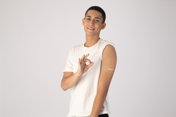 Young man is making an okay hand gesture while smiling