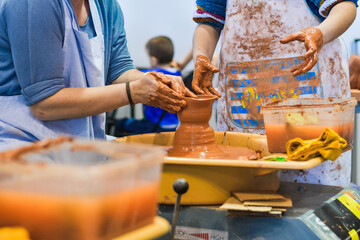 Detailed view of clay being shaped on a pottery wheel during a ceramic crafting session.