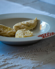 Homemade traditional Sardinian pasta called Culurgiones on a porcelain plate