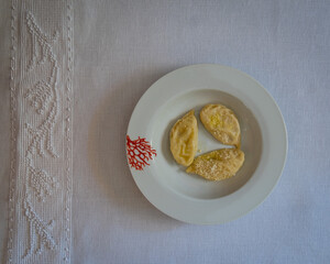 Homemade traditional Sardinian pasta called Culurgiones on a porcelain plate